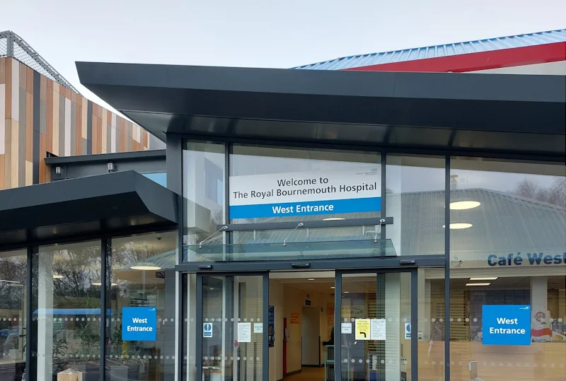 An example of a hospital entrance with automatic doors and signs.